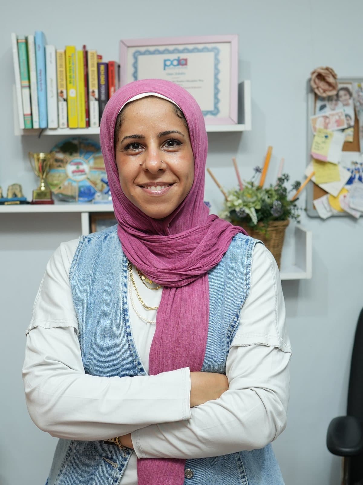 Alaa Osama Jalaby, co-founder and general manager, standing beside her Montessori and Positive Discipline certificates
