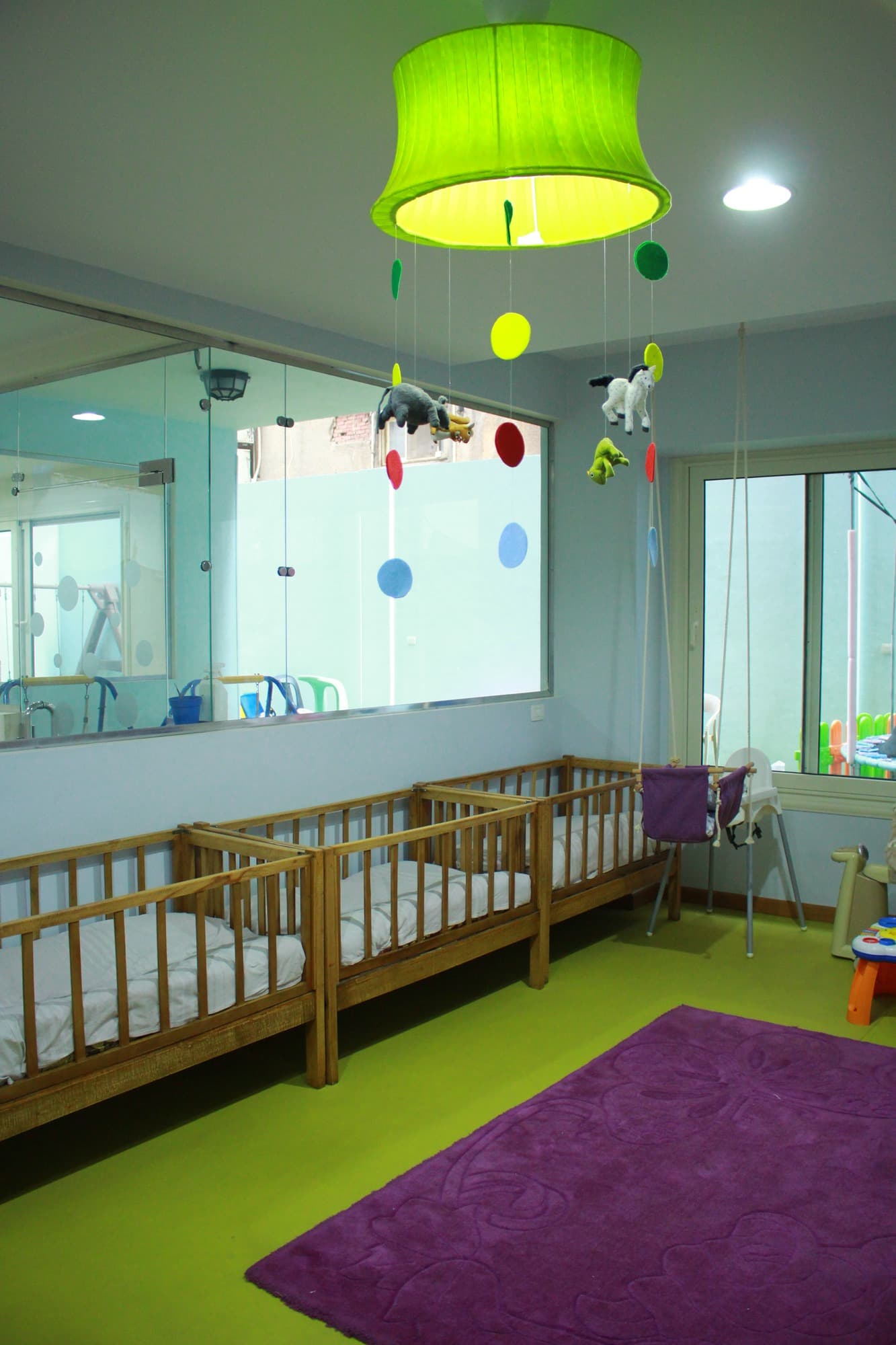 The infant corner with wooden cots, a rocker and soft furnishings