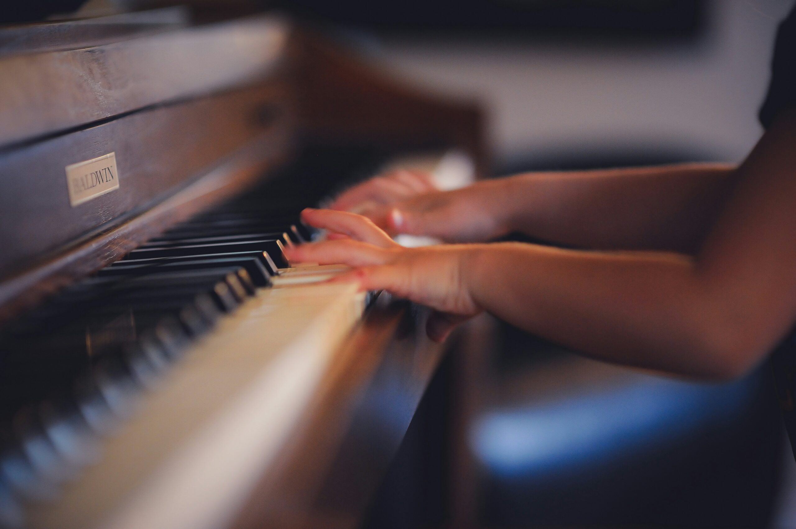 Close-up of a child playing the piano at SuperKidz nursery in Cairo, Egypt, showcasing focused expression and small hands on the keys, highlighting musical engagement in an early learning environment.