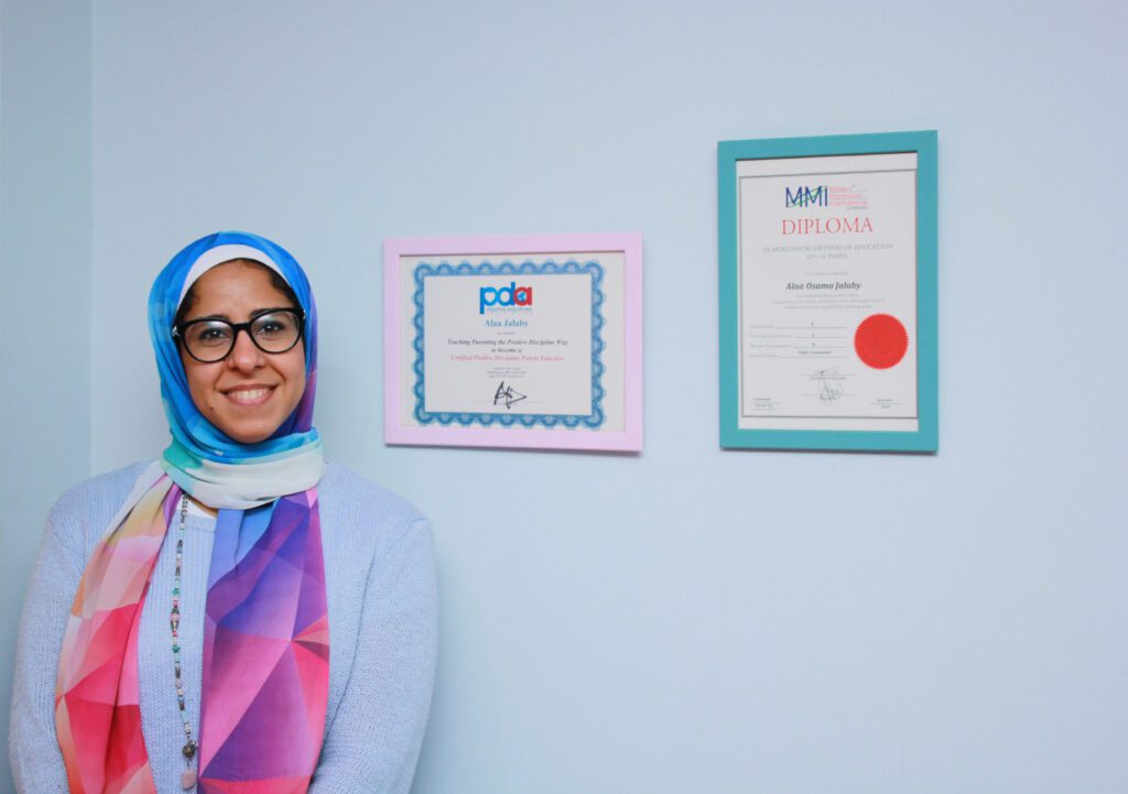 A woman in a headscarf stands beside framed certificates at Superkidz nursery in Giza, Cairo, Egypt.